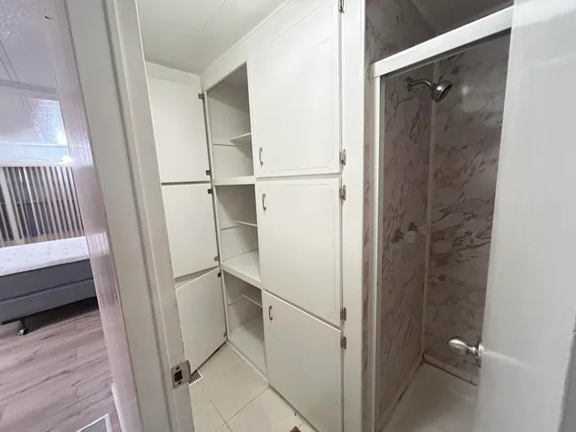 a bathroom with a granite countertop sink a mirror and a shower