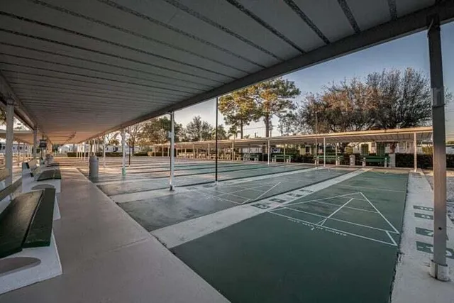 a view of a street with a building and palm trees