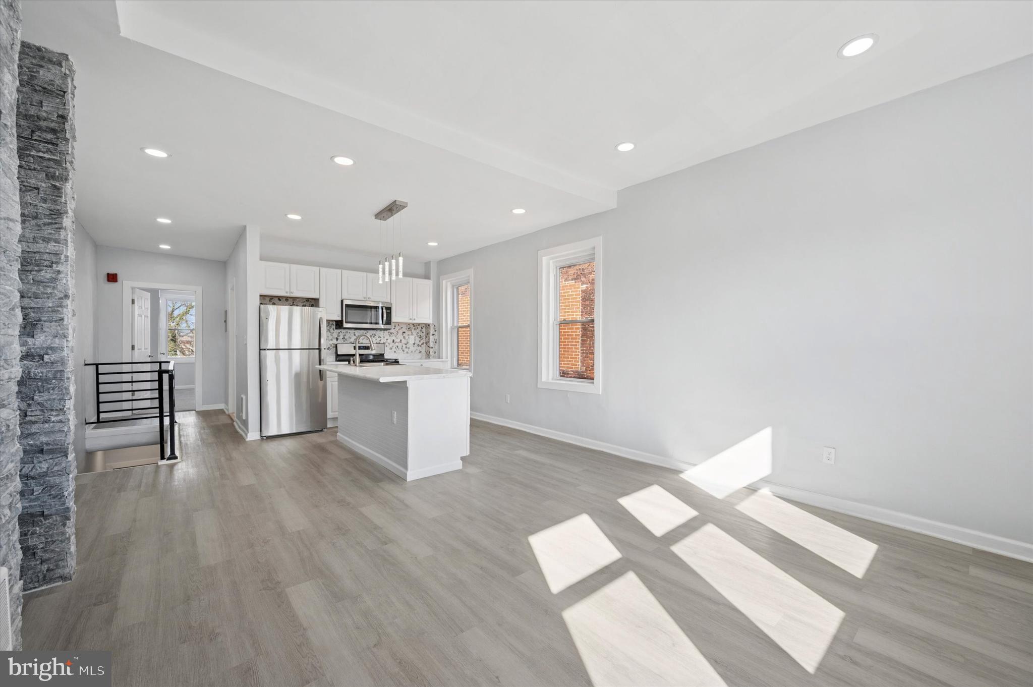 5031 Walnut Street, Unit 3 Philadelphia, PA 19139 - Photo 3 of 7 a view of a kitchen with wooden floor and windows