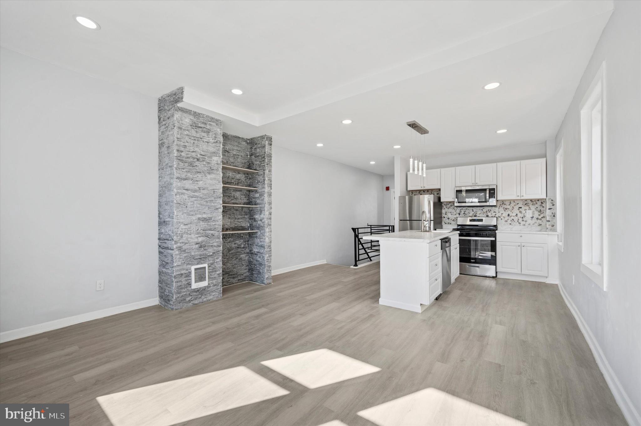 5031 Walnut Street, Unit 3 Philadelphia, PA 19139 - Photo 4 of 7 a view of kitchen with kitchen island wooden floors and stainless steel appliances