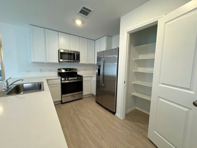 a kitchen with granite countertop a refrigerator and a sink