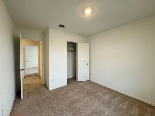 an empty room with closet and a bathroom