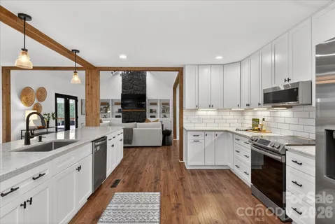 a kitchen with granite countertop white cabinets and white appliances