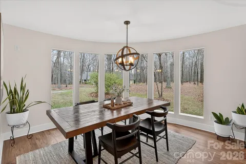 a dining room with furniture wooden floor and a chandelier