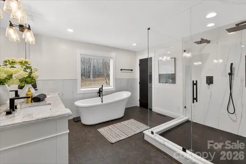 a bathroom with a tub sink and mirror