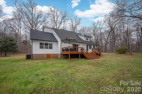 a view of a house with a yard and trees