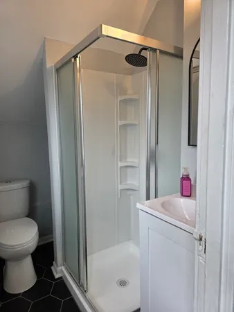 a bathroom with a granite countertop toilet and a shower