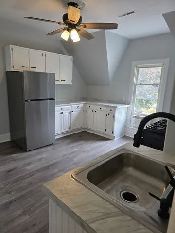 a kitchen with a sink a refrigerator and cabinets