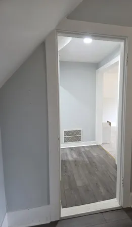 an empty room with windows and chandelier fan