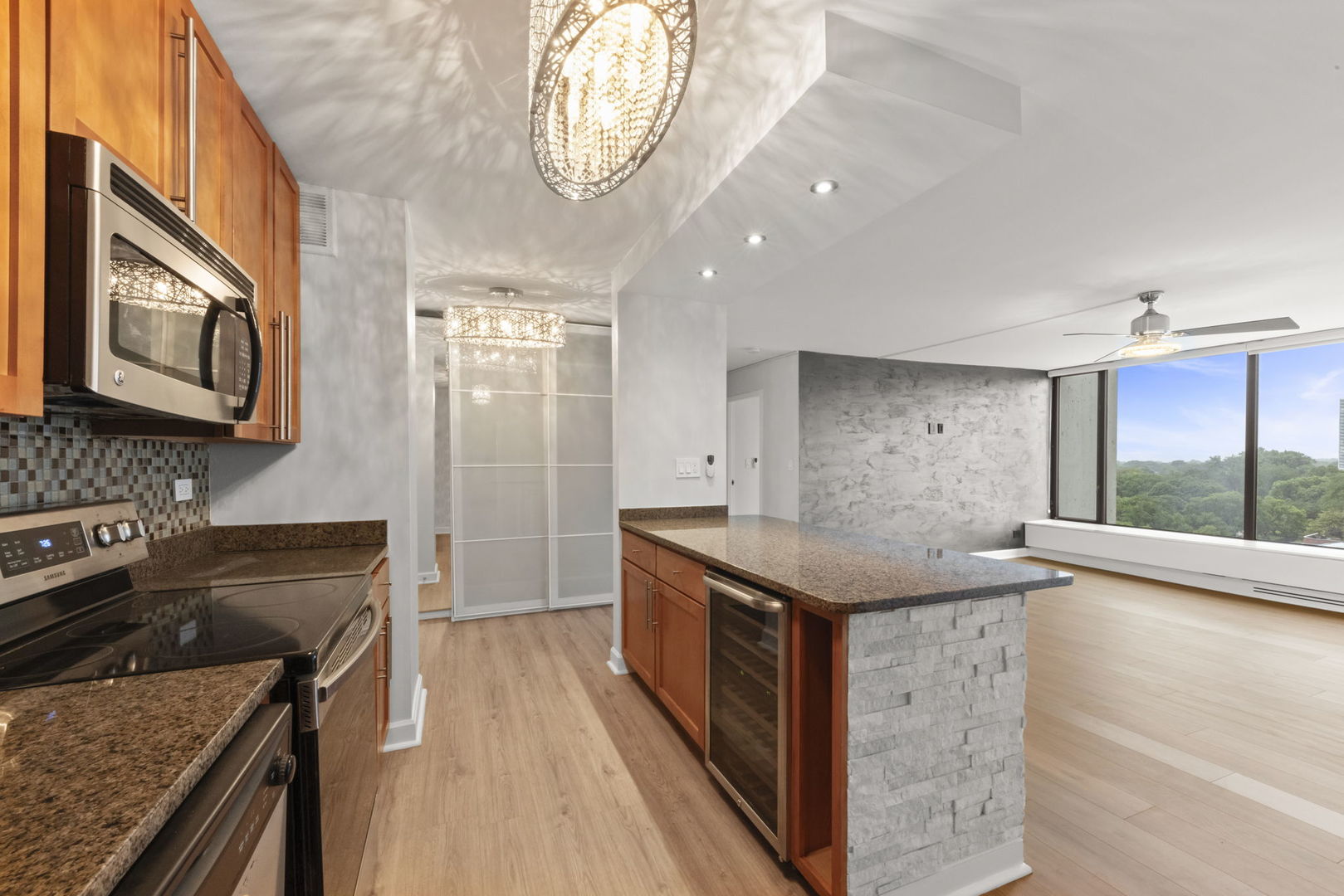 5455 North Sheridan Road, Unit 908 Chicago, IL 60640 - Photo 14 of 21 a kitchen with granite countertop cabinets stainless steel appliances a counter space and a window