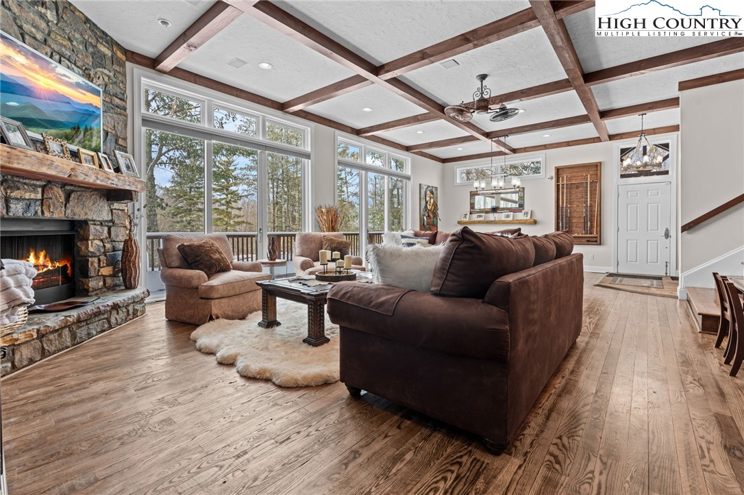 123 St Andrews Road Beech Mountain, NC 28604 - Photo 24 of 50 a living room with furniture a fireplace and a floor to ceiling window