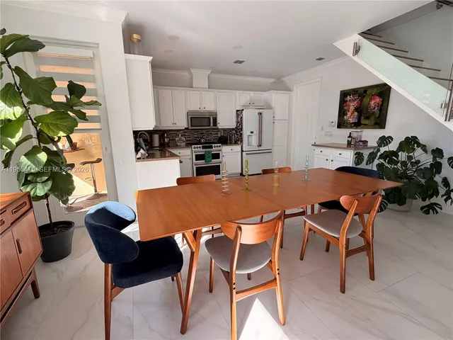 a living room with furniture kitchen view and a window
