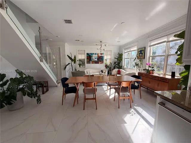 a living room with furniture a chandelier and a flat screen tv
