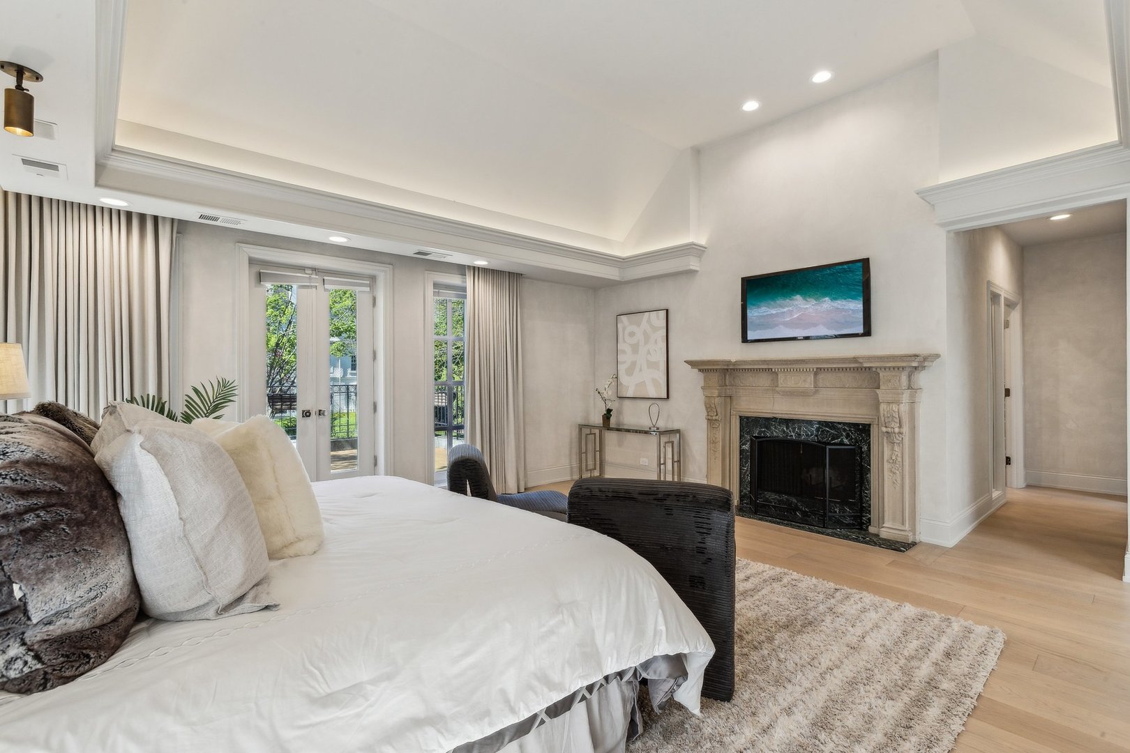 579 West Hawthorne Place Chicago, IL 60657 - Photo 32 of 65 a bedroom with a large bed and a fireplace