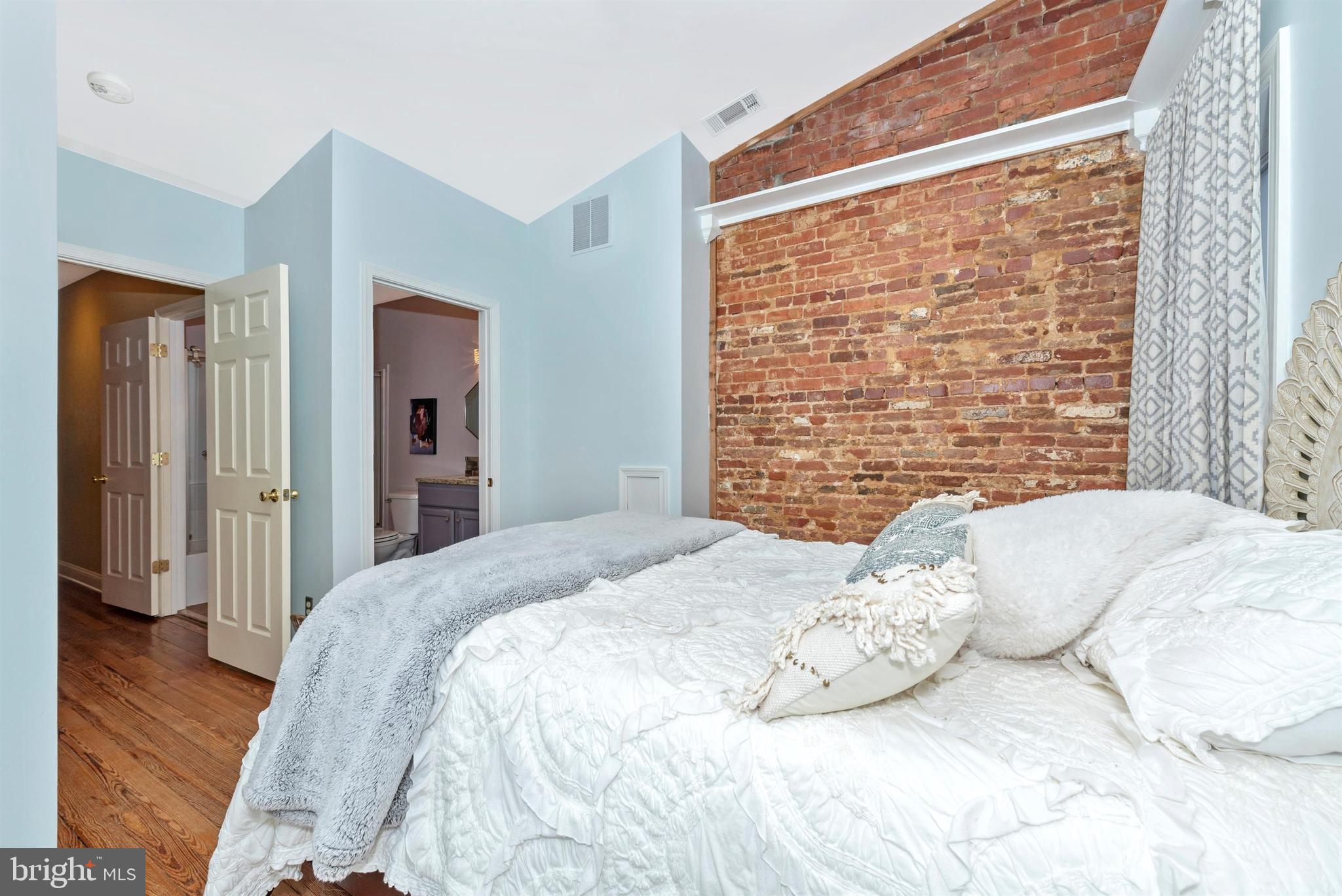 207 Center Street Frederick, MD 21701 - Photo 17 of 36 First of two master suites - exposed brick wall.