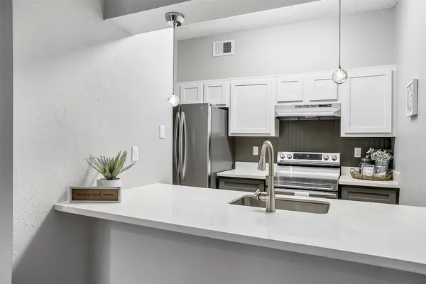 a kitchen with granite countertop a refrigerator and a stove