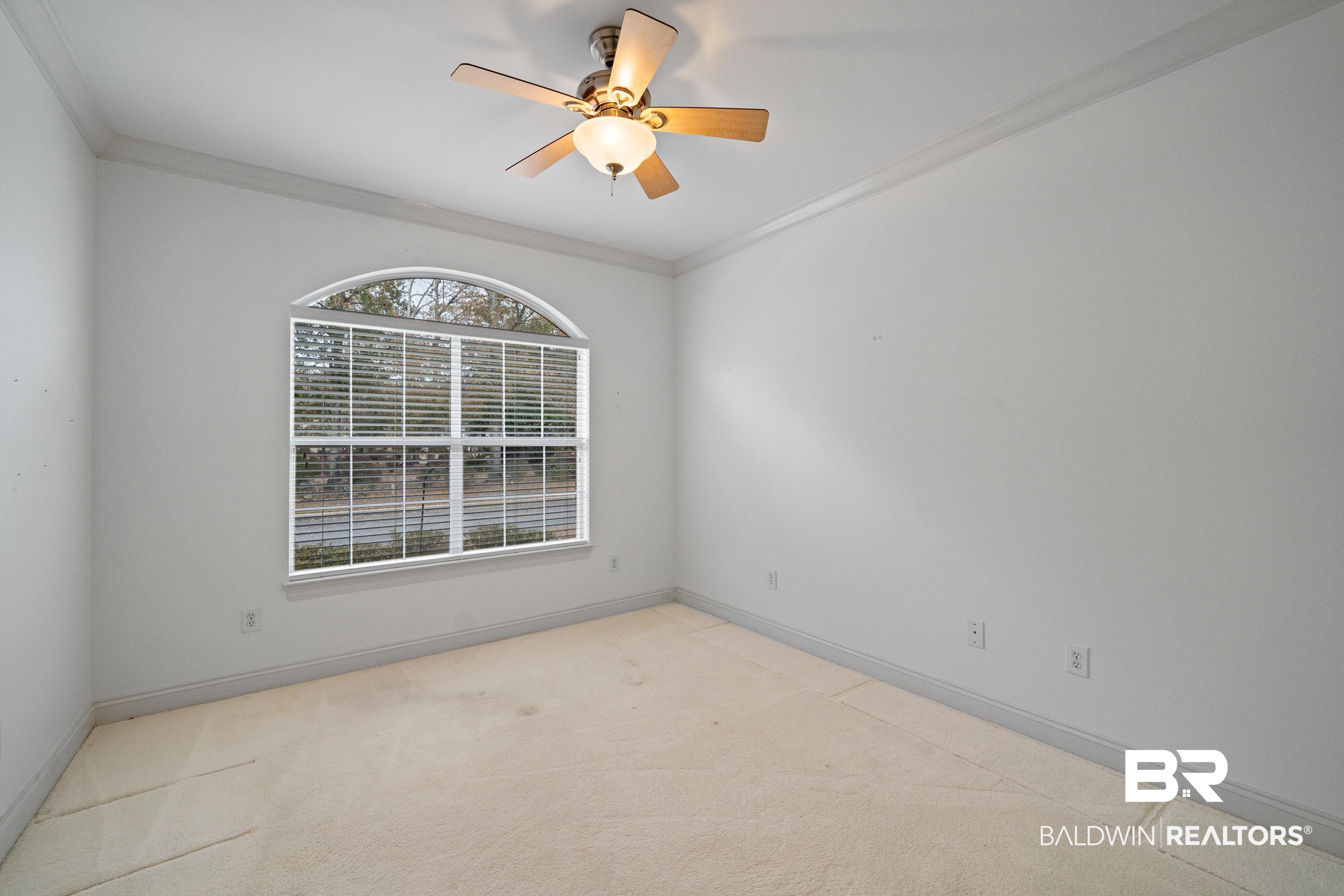 404 Savannah Lane Foley, AL 36535 - Photo 21 of 29 Unfurnished room with light carpet, baseboards, a ceiling fan, and crown molding