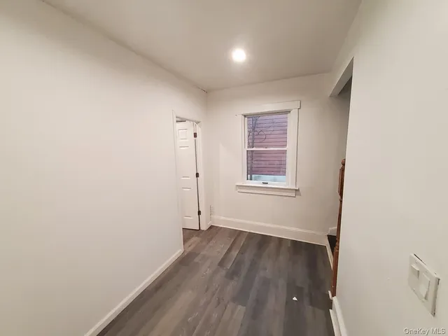 a view of a room with wooden floor and window