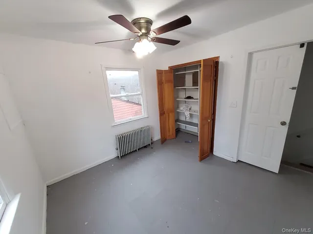 an empty room with closet and windows