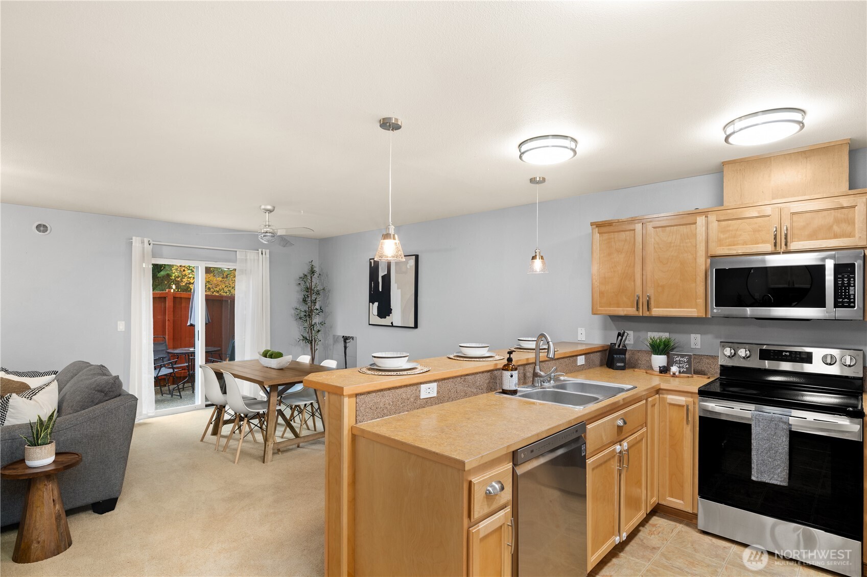 16015 123rd Ave Court East Puyallup, WA 98374 - Photo 11 of 26 a kitchen with a stove a sink a dining table and chairs