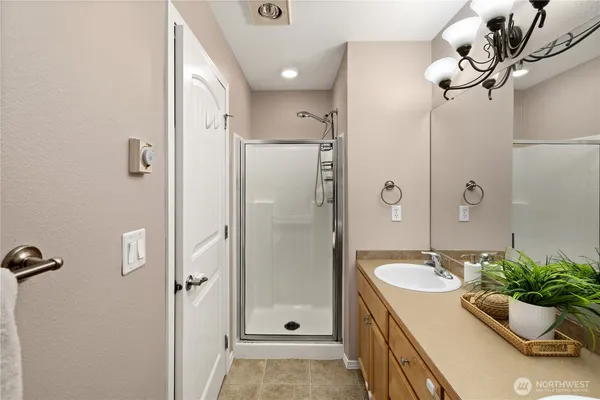 a bathroom with a granite countertop sink a mirror and a shower