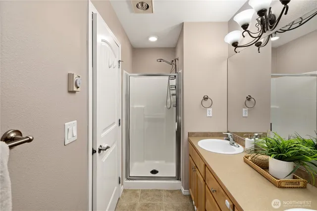 a bathroom with a granite countertop sink a mirror and a shower