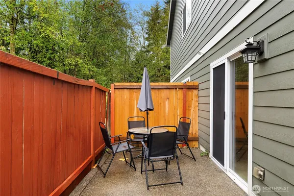 a view of a patio with table and chairs and wooden fence
