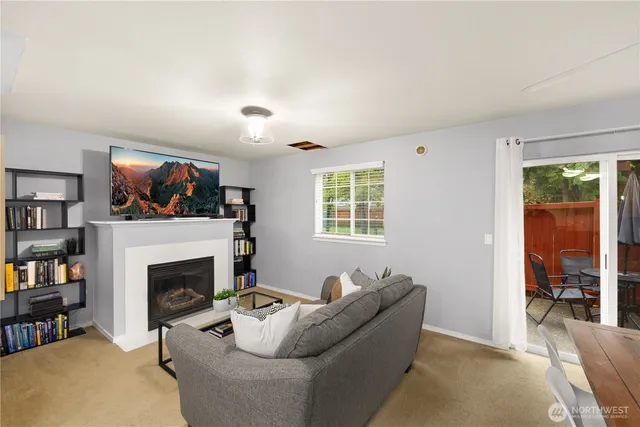 a living room with furniture a flat screen tv and a fireplace
