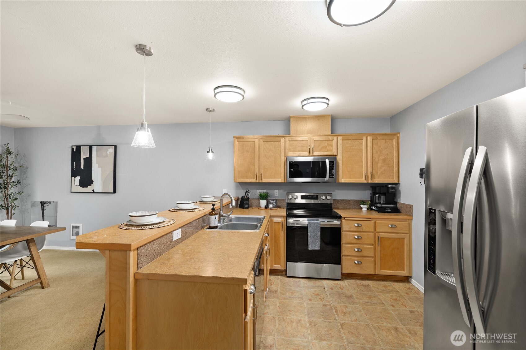 16015 123rd Ave Court East Puyallup, WA 98374 - Photo 10 of 26 a kitchen with stainless steel appliances kitchen island granite countertop a sink refrigerator stove and microwave