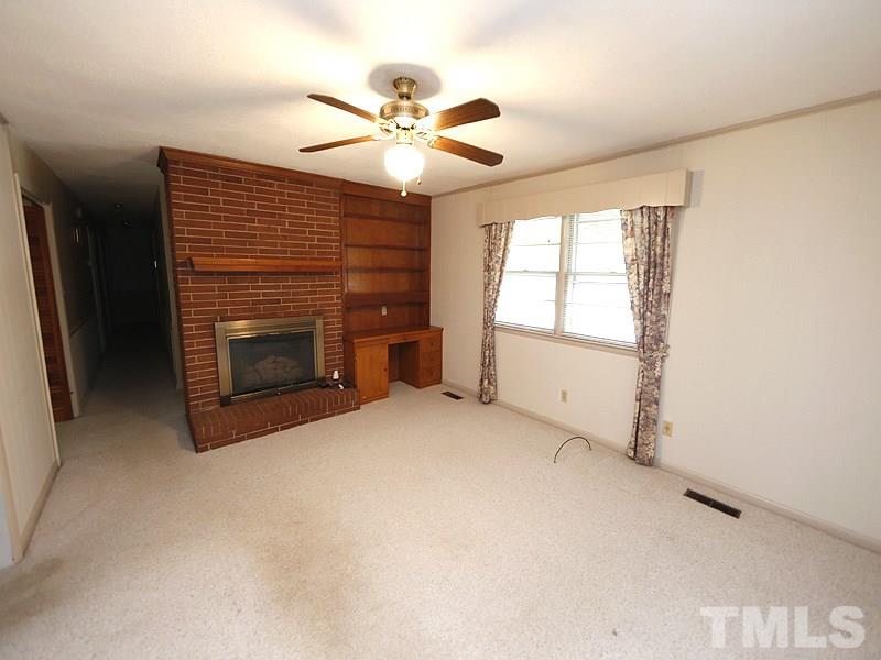 4801 Greenbrier Road Raleigh, NC 27603 - Photo 5 of 12 a view of empty room with window and fireplace