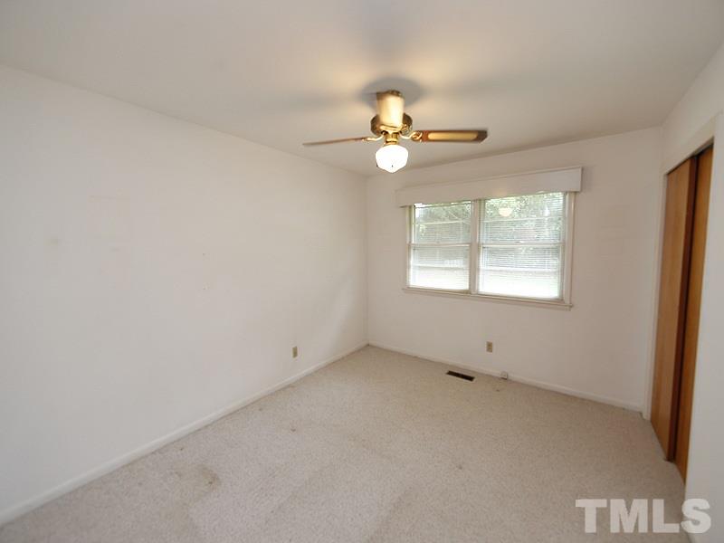 4801 Greenbrier Road Raleigh, NC 27603 - Photo 6 of 12 an empty room with windows and chandelier fan
