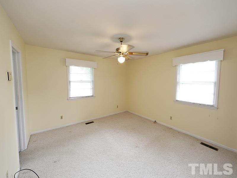 4801 Greenbrier Road Raleigh, NC 27603 - Photo 9 of 12 an empty room with a window and a ceiling fan
