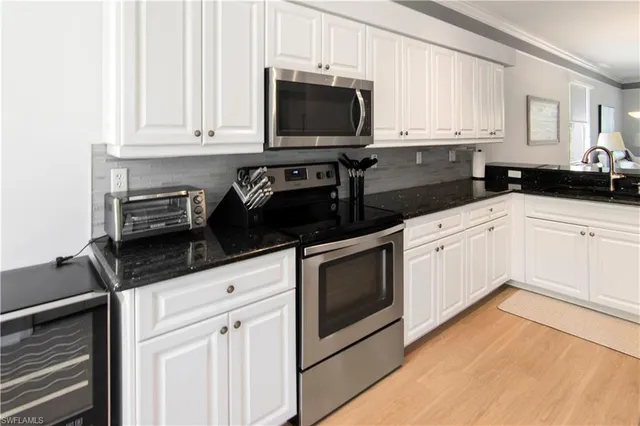 a kitchen with granite countertop a refrigerator and a sink