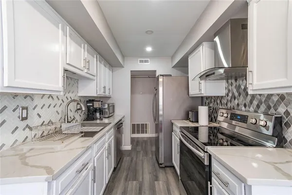 a kitchen with stainless steel appliances granite countertop a sink stove and refrigerator