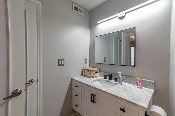 a bathroom with a granite countertop sink and a mirror
