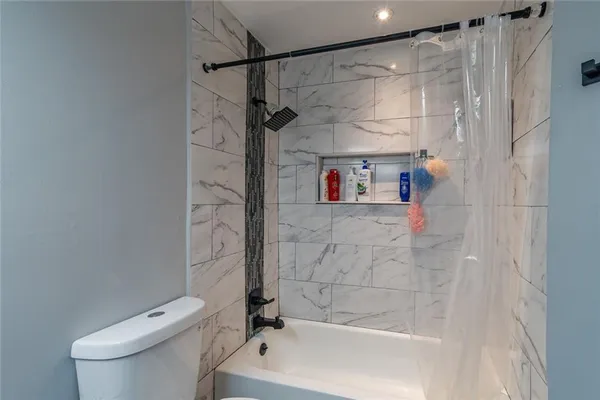 a bathroom with a shower a toilet and a shower