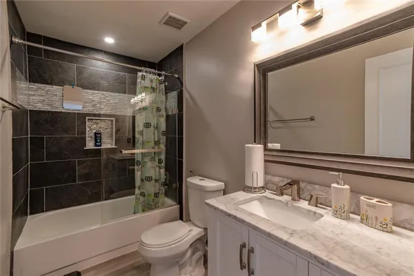 a bathroom with a granite countertop sink toilet and shower