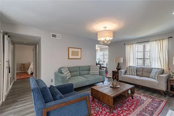 a living room with furniture a rug and a chandelier