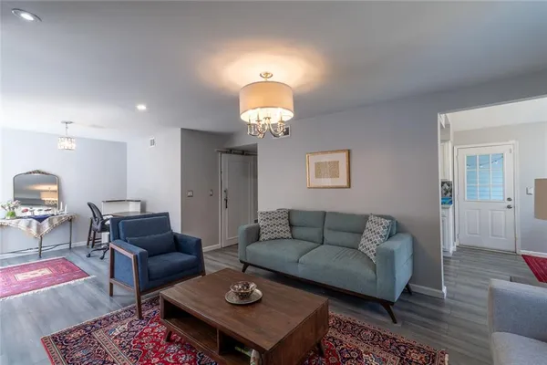 a living room with furniture a lamp and a chandelier