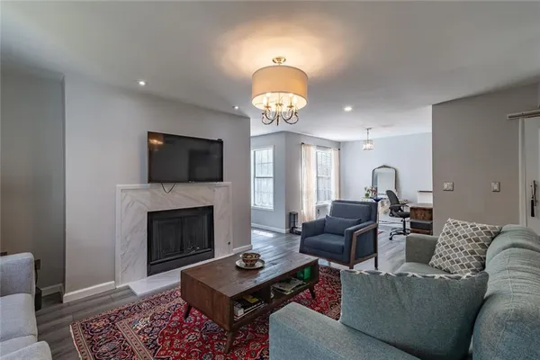 a living room with furniture a fireplace and a chandelier