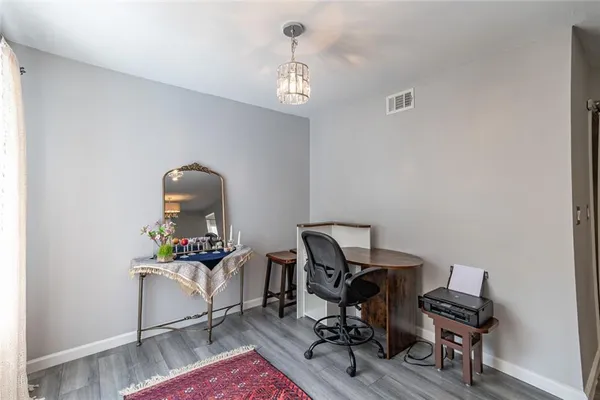 a view of a workspace with furniture and wooden floor