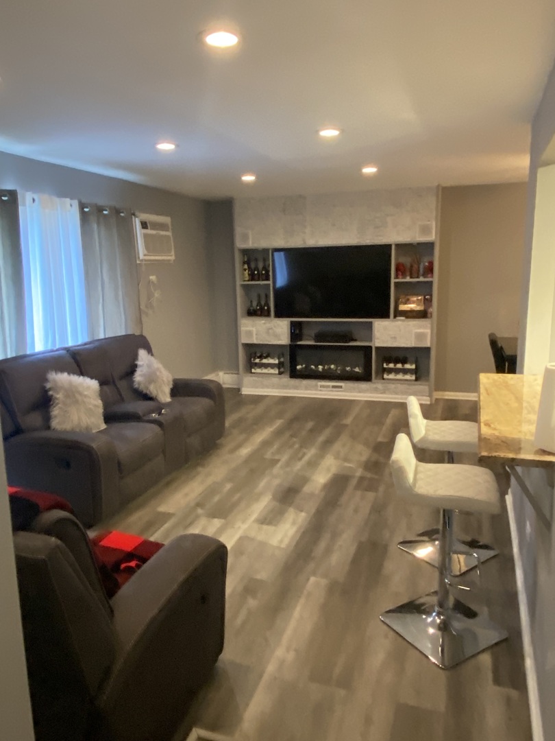 7000 Mather Avenue, Unit 101 Chicago Ridge, IL 60415 - Photo 11 of 21 a living room with furniture and a flat screen tv