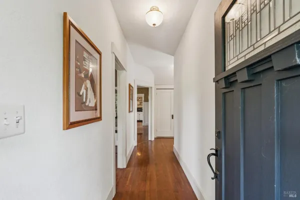 a view of a hallway with wooden floor and staircase