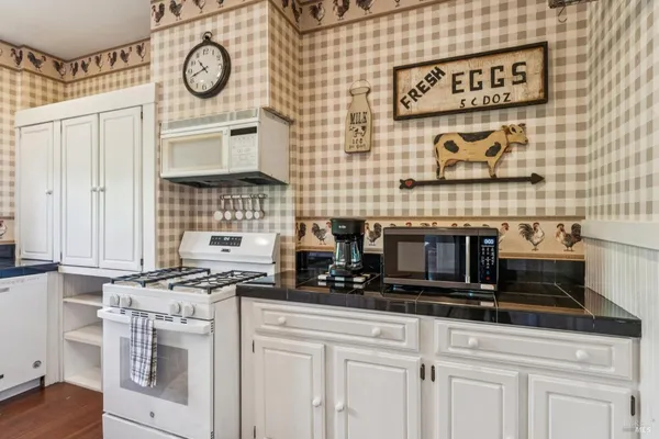 a kitchen with a stove and a clock on the wall