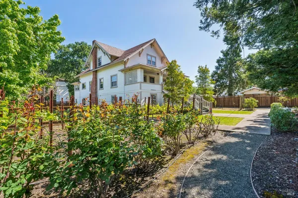 a front view of a house with a yard and trees