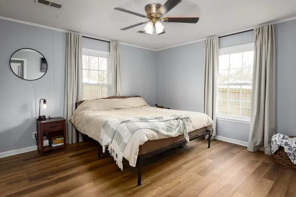 a bed sitting in a spacious bedroom next to a window