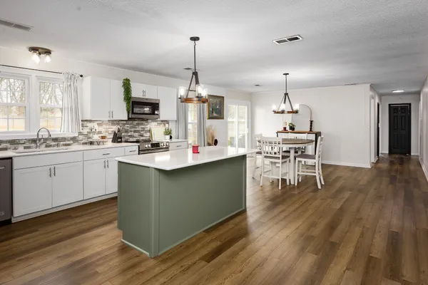 a kitchen with a sink cabinets and wooden floor