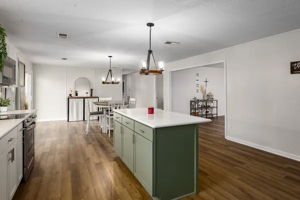 a kitchen that has a lot of cabinets and wooden floor