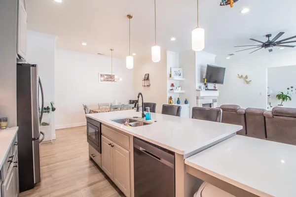 a kitchen that has a sink a counter space and stainless steel appliances