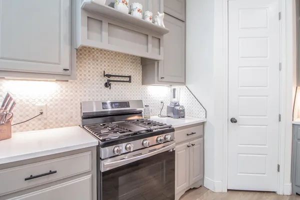 a kitchen with granite countertop white cabinets and a stove